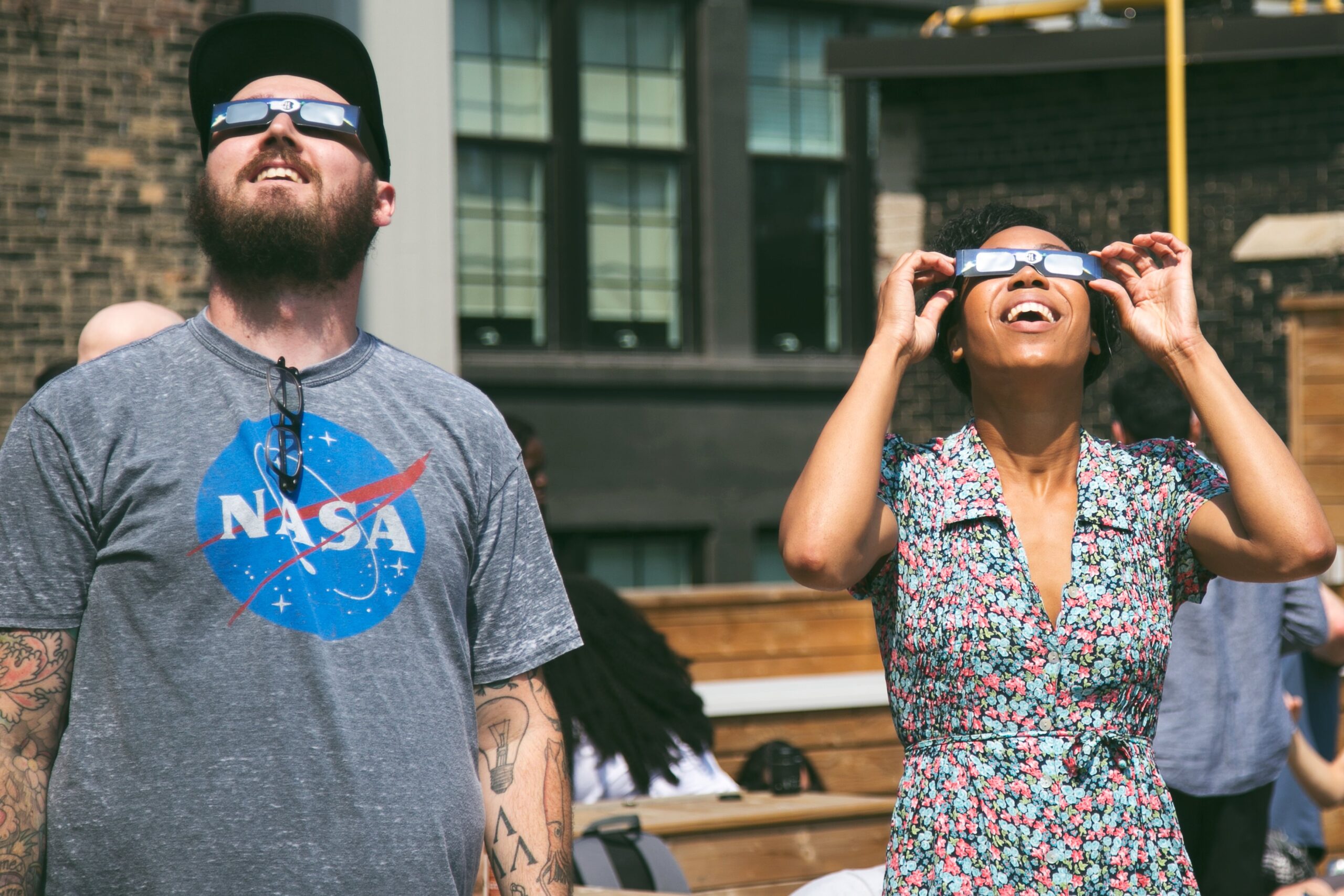 two people looking at the sky with protective glasses for an eclipse
