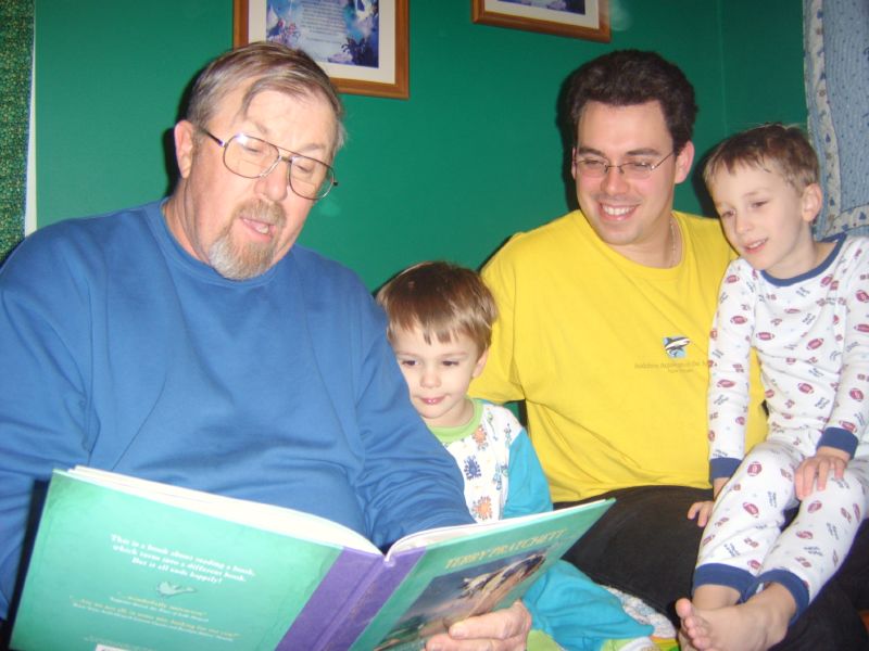Grandpa reading to 2 kids and an adult