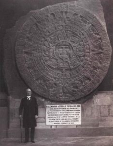 Man standing in front of Aztec calendar