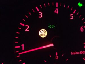A picture of a auto gauge with the check engine light on.