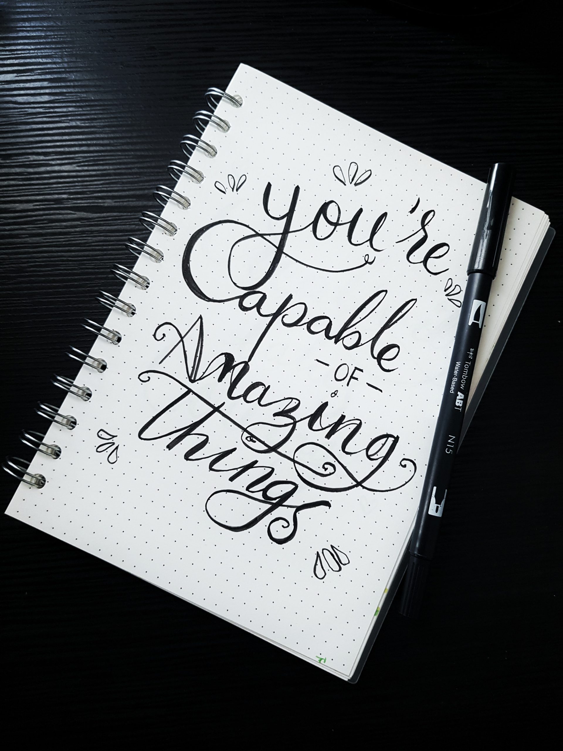 A picture of a notebook that says, "You're capable of amazing things."